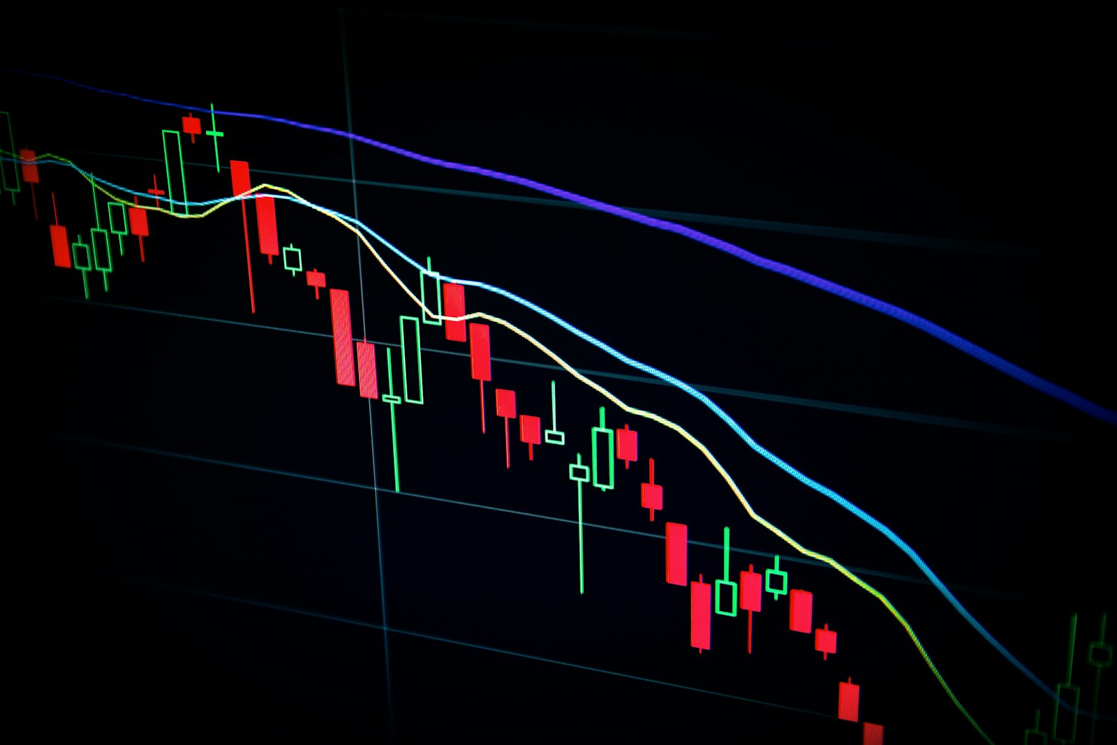 A declining candlestick chart on a dark screen